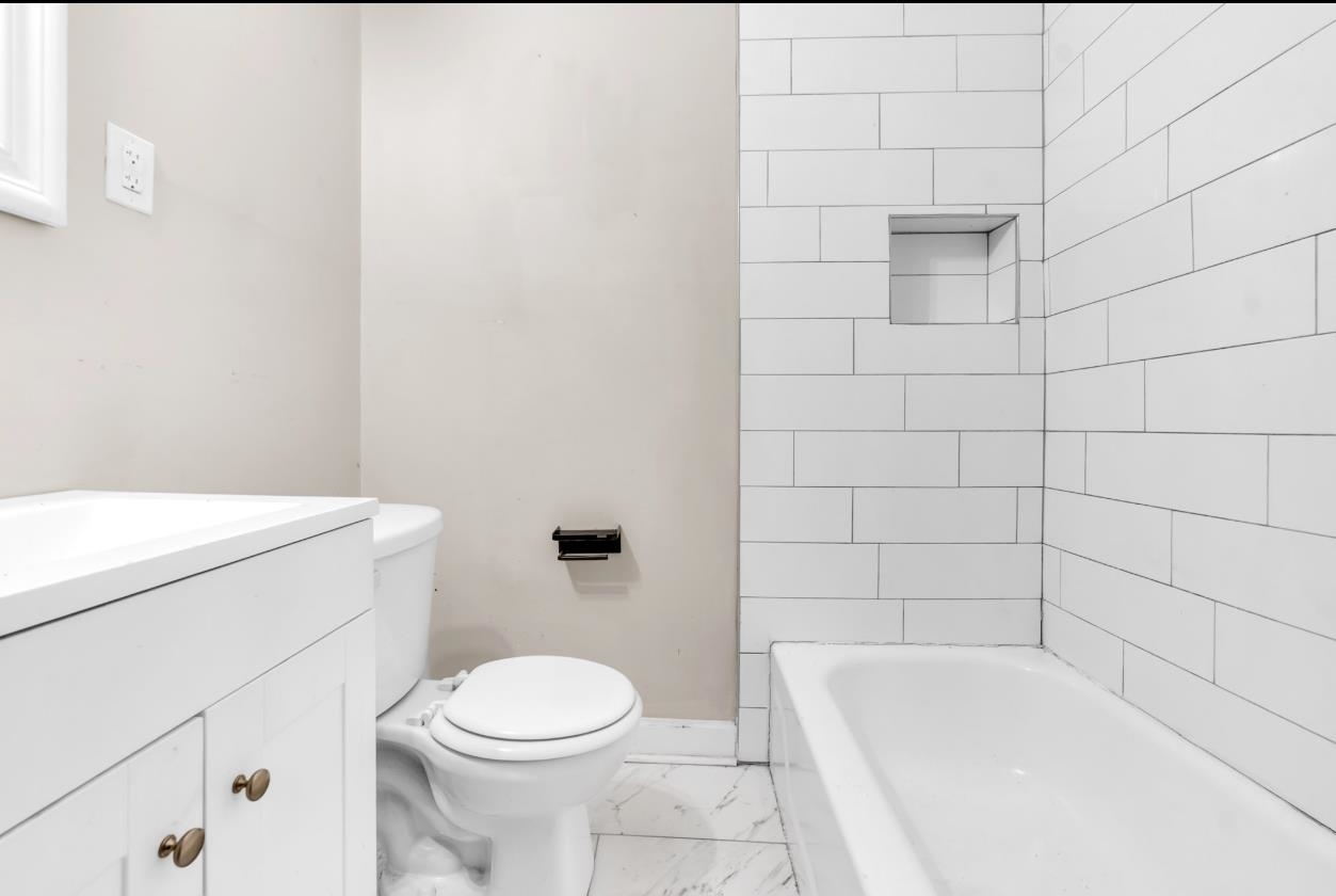 1148 Rozelle Street Memphis, TN 38106 - Photo 14 of 16 a bathroom with a toilet and bathtub