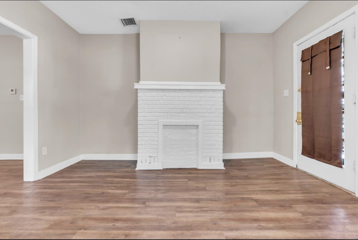 1148 Rozelle Street Memphis, TN 38106 - Photo 5 of 16 a view of an empty room with wooden floor and a window