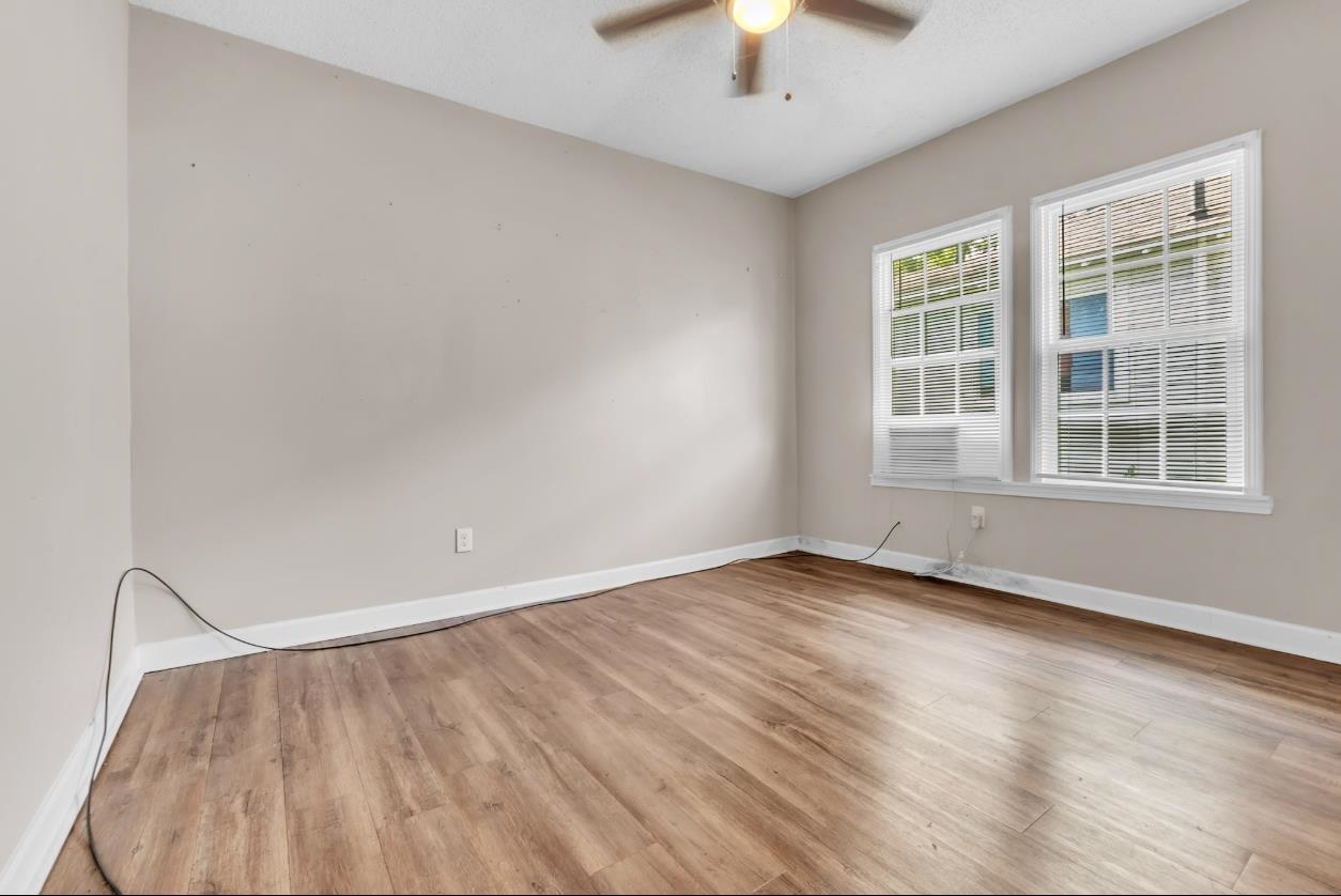 1148 Rozelle Street Memphis, TN 38106 - Photo 7 of 16 an empty room with chandelier fan and windows
