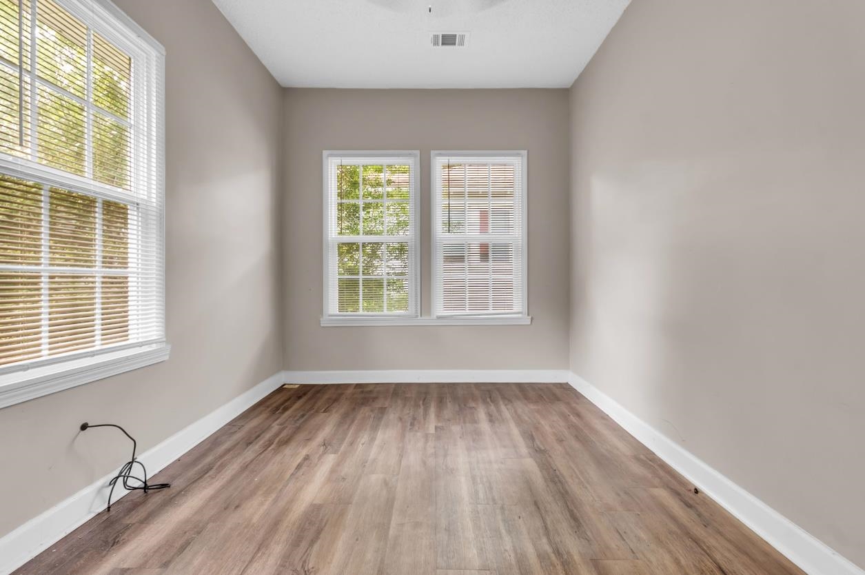 1148 Rozelle Street Memphis, TN 38106 - Photo 8 of 16 an empty room with wooden floor and windows