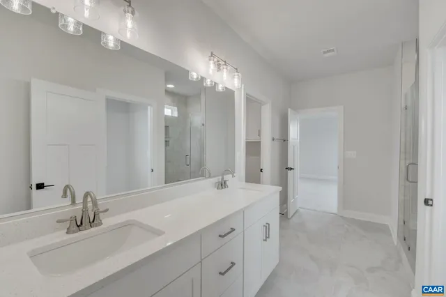 a bathroom with double vanity sinks and a mirror