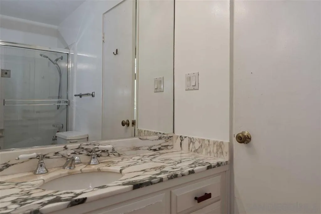 1228 Cave Street La Jolla, CA 92037 - Photo 17 of 22 a bathroom with a granite countertop sink and mirror