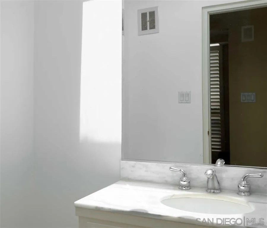 1228 Cave Street La Jolla, CA 92037 - Photo 18 of 22 a bathroom with a sink and a mirror