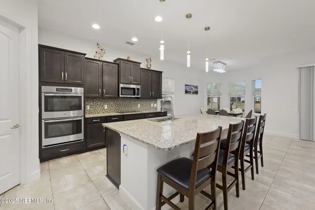 a kitchen with stainless steel appliances granite countertop a sink a stove and a refrigerator
