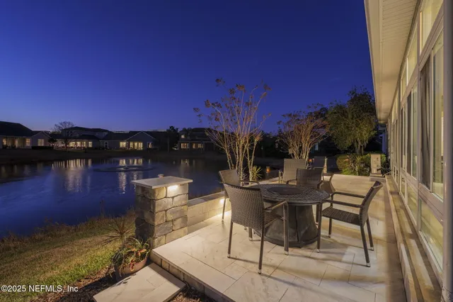 a view of a house with backyard water fountain and sitting area