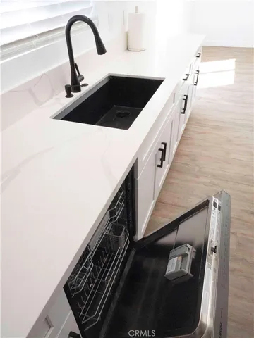 a kitchen with a sink and white cabinets
