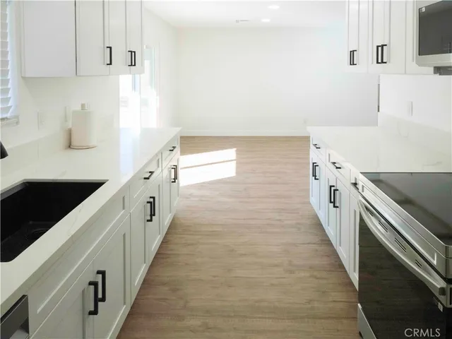 a kitchen with granite countertop white cabinets and white appliances