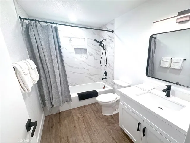 a bathroom with a sink a toilet a mirror and shower