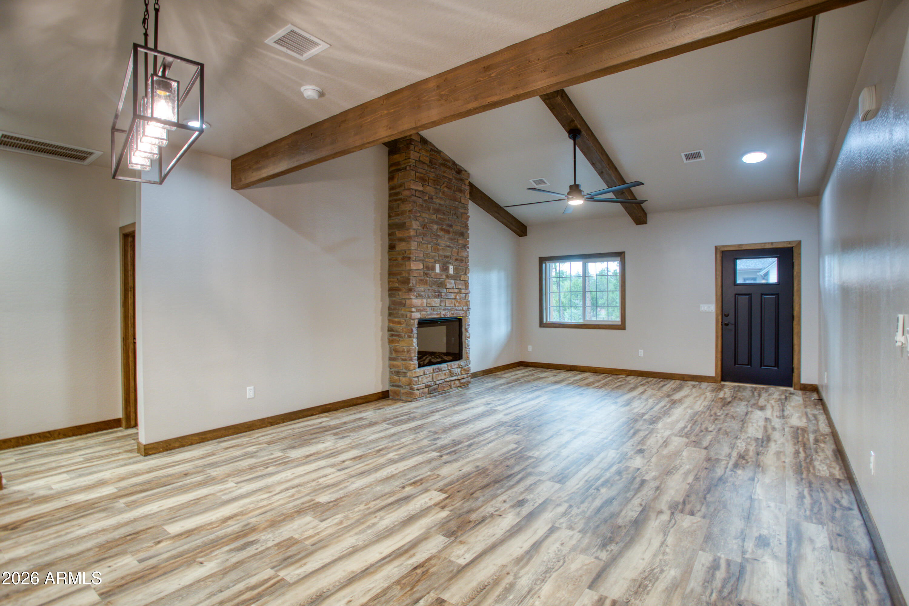 620 Campbell Lane Show Low, AZ 85901 - Photo 5 of 52 a view of an empty room with wooden floor and a window