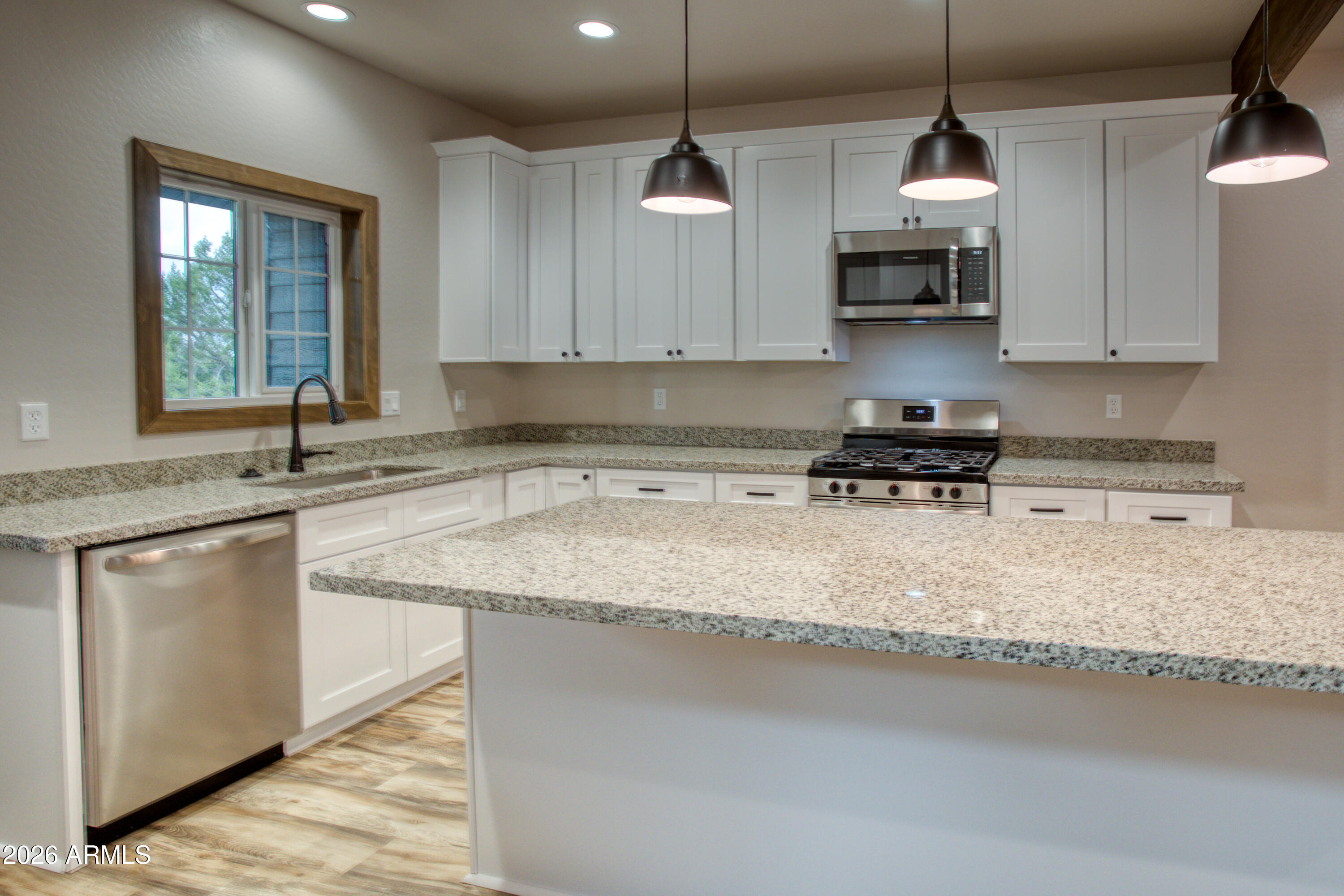 620 Campbell Lane Show Low, AZ 85901 - Photo 7 of 52 a kitchen with stainless steel appliances granite countertop a sink a stove a microwave and wooden cabinets