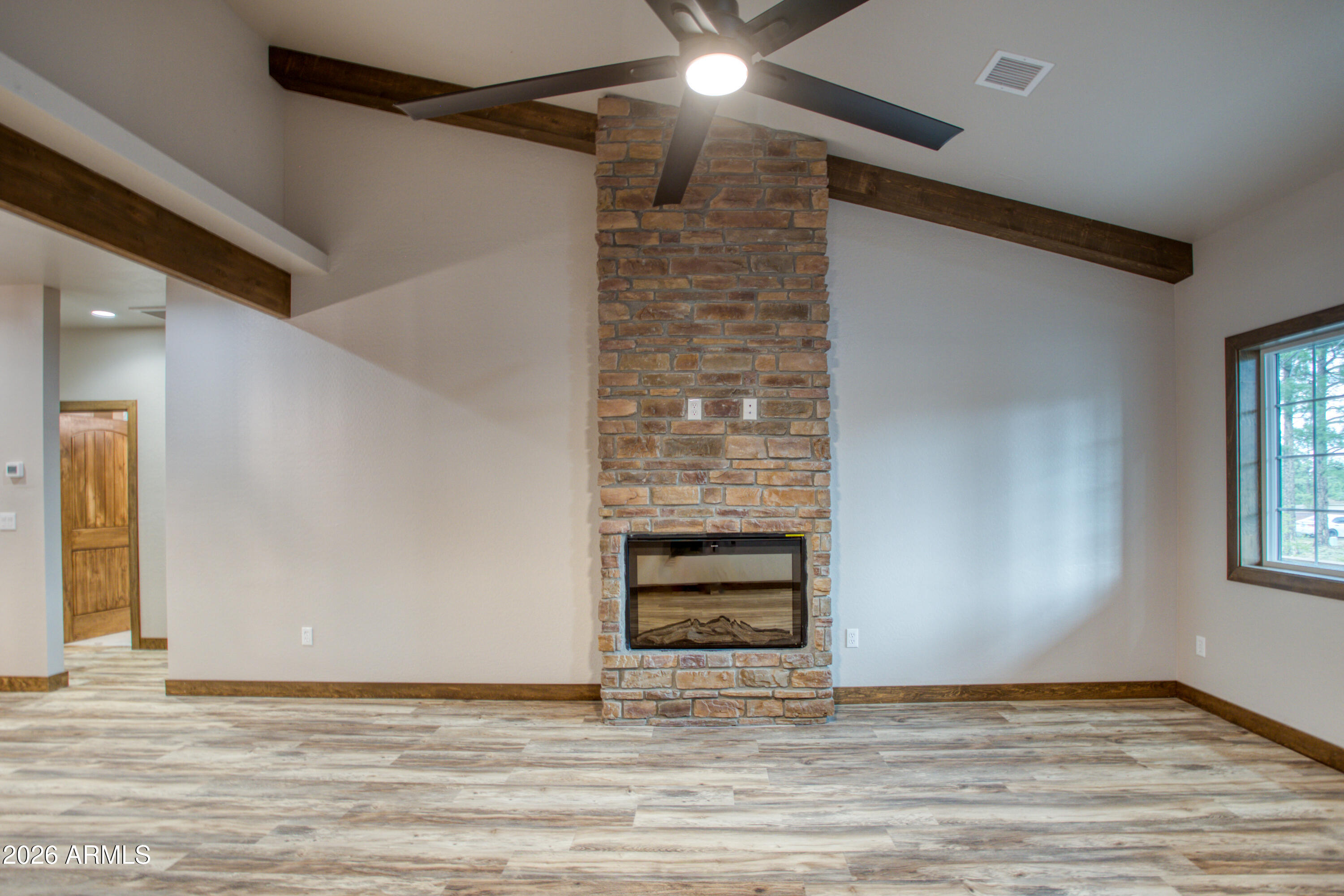 620 Campbell Lane Show Low, AZ 85901 - Photo 9 of 52 a view of an empty room with wooden floor and a window