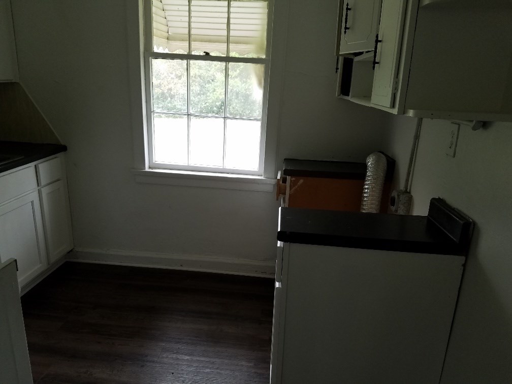 4023 6th Avenue Columbus, GA 31904 - Photo 7 of 9 a kitchen with a sink a refrigerator freezer and a window
