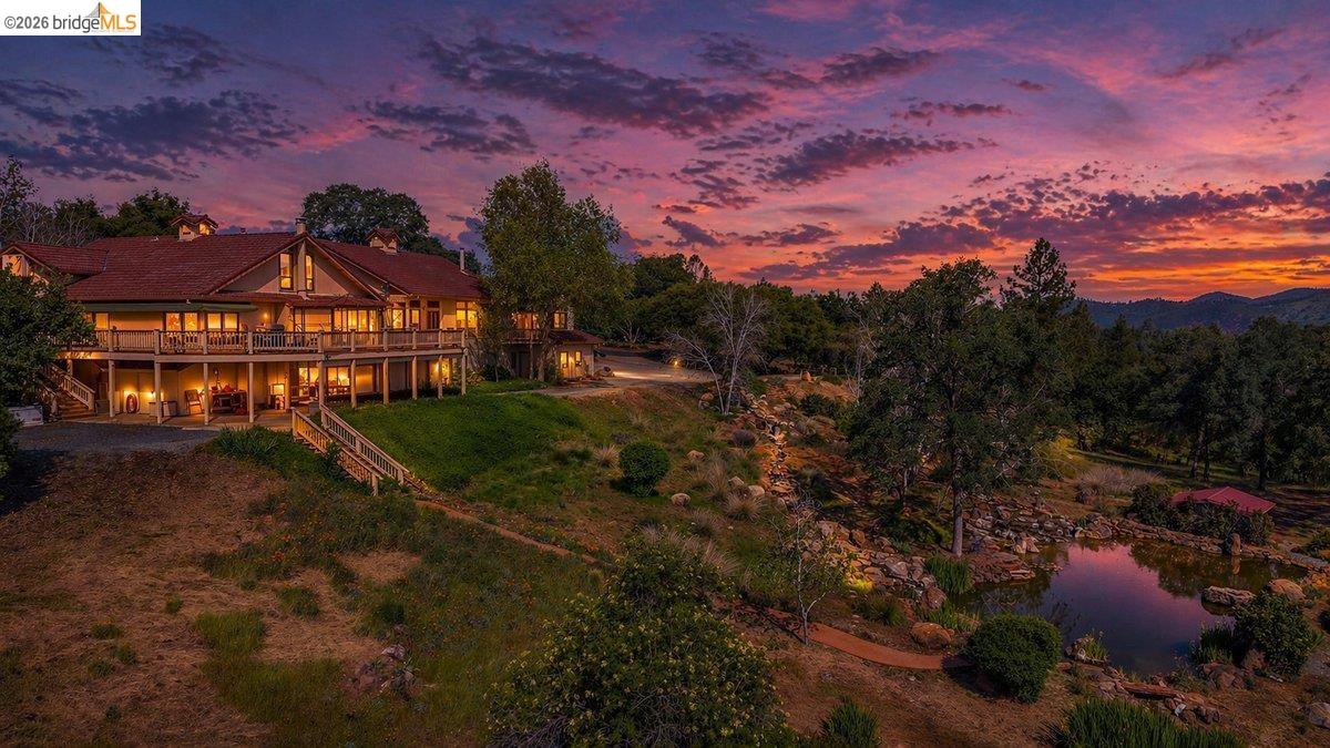 Hillside property featuring a multi-level house with extensive balconies and a red tile roof