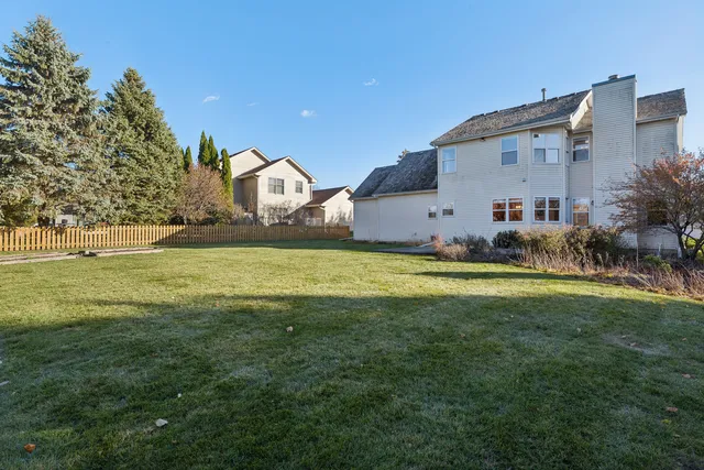 a view of a house with a big yard and large trees
