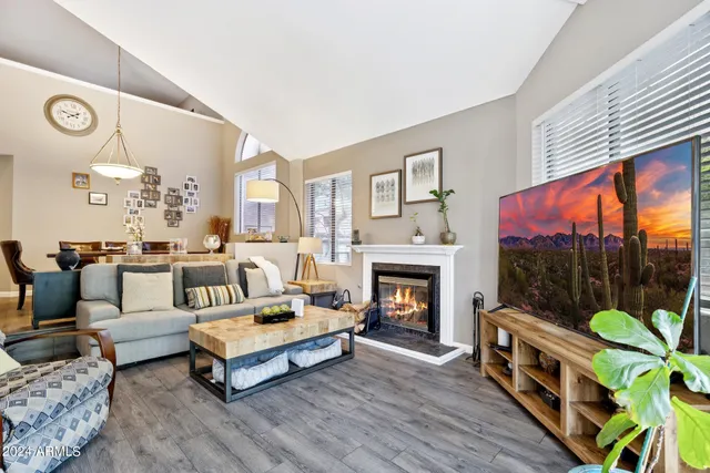 a living room with furniture a flat screen tv and a fireplace