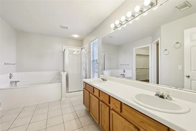 a spacious bathroom with a tub sink and mirror