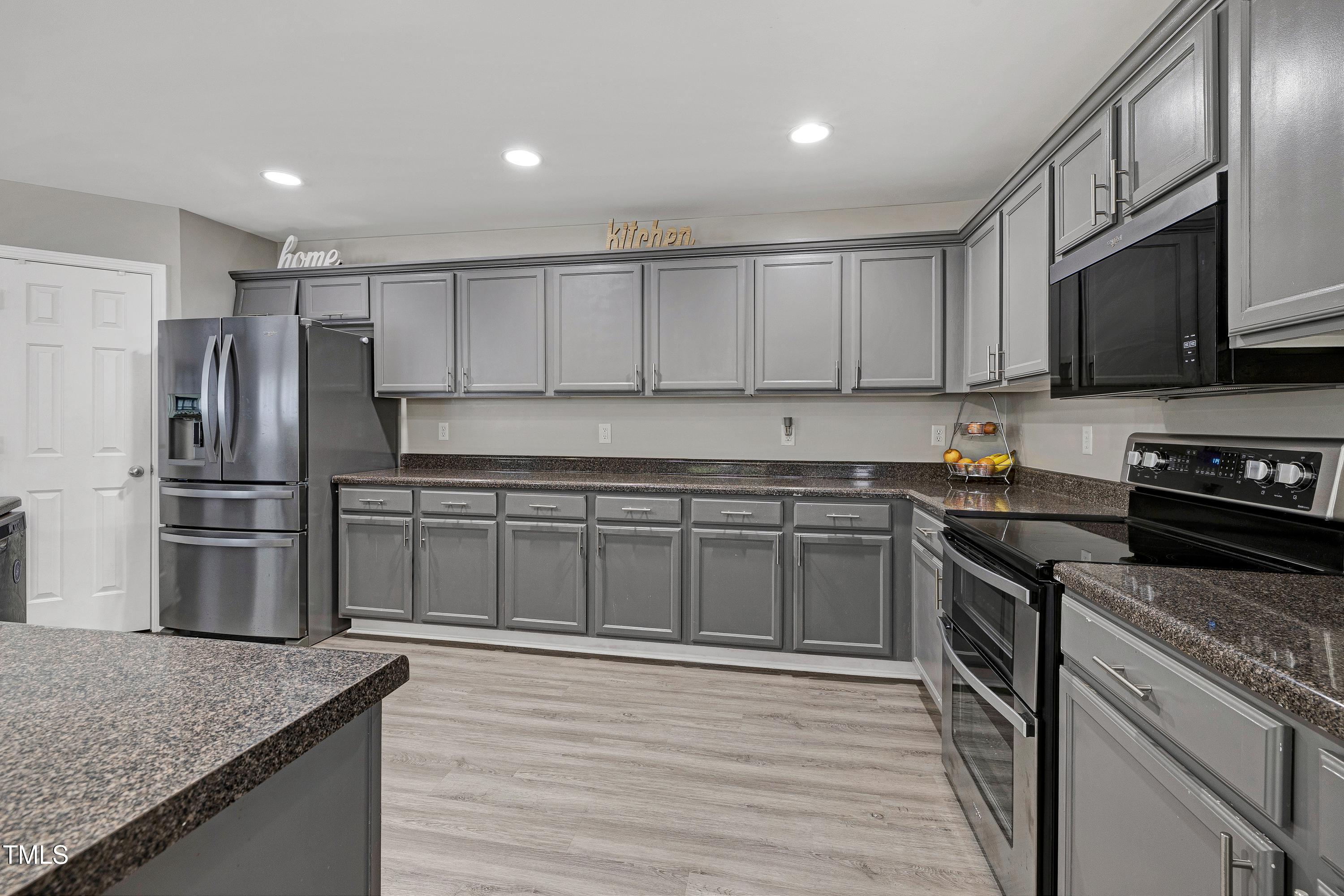 5428 Meryton Park Way Raleigh, NC 27616 - Photo 12 of 29 a kitchen with stainless steel appliances granite countertop a stove top oven a sink and dishwasher