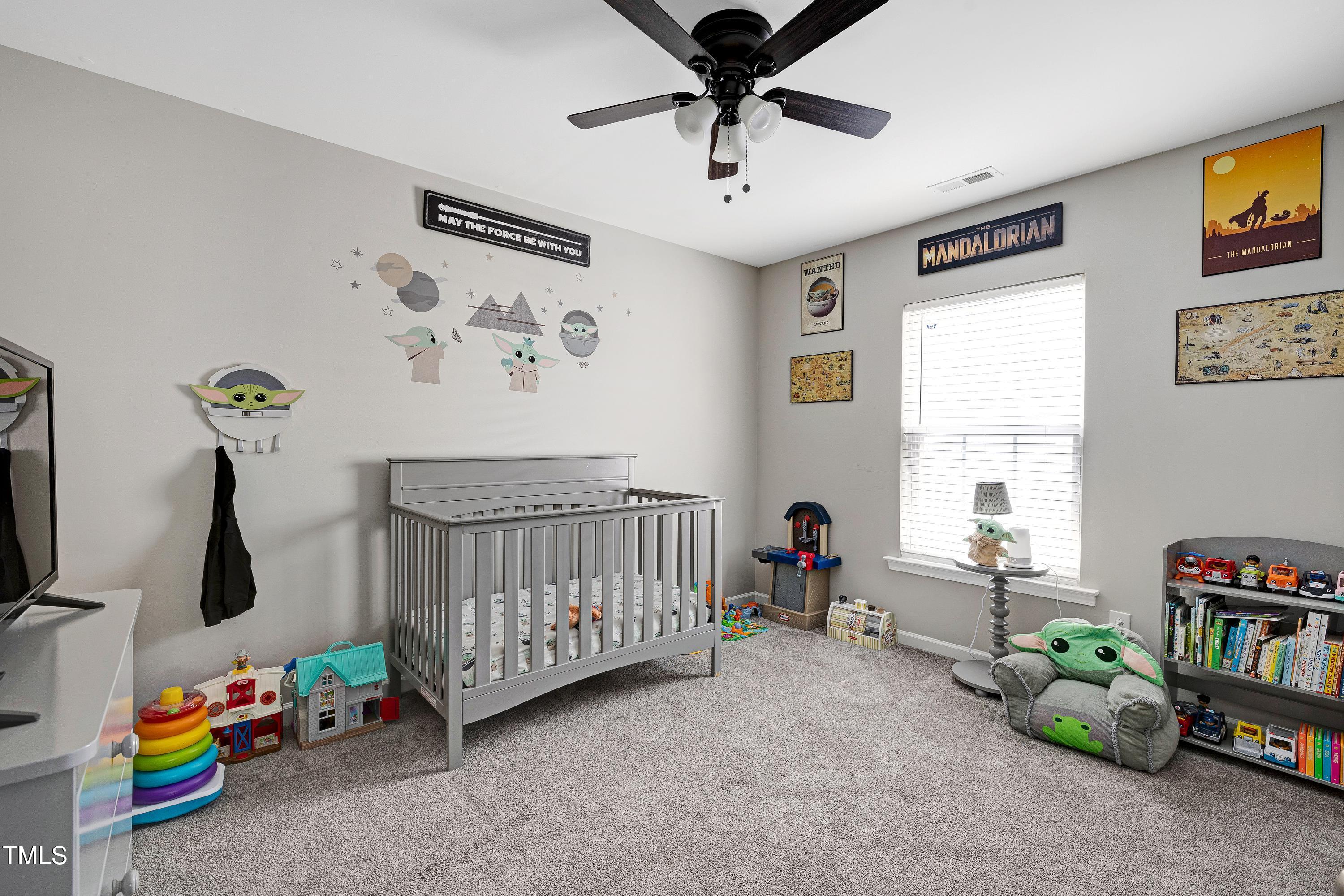 5428 Meryton Park Way Raleigh, NC 27616 - Photo 20 of 29 a bedroom with a baby bed a chandelier and a window