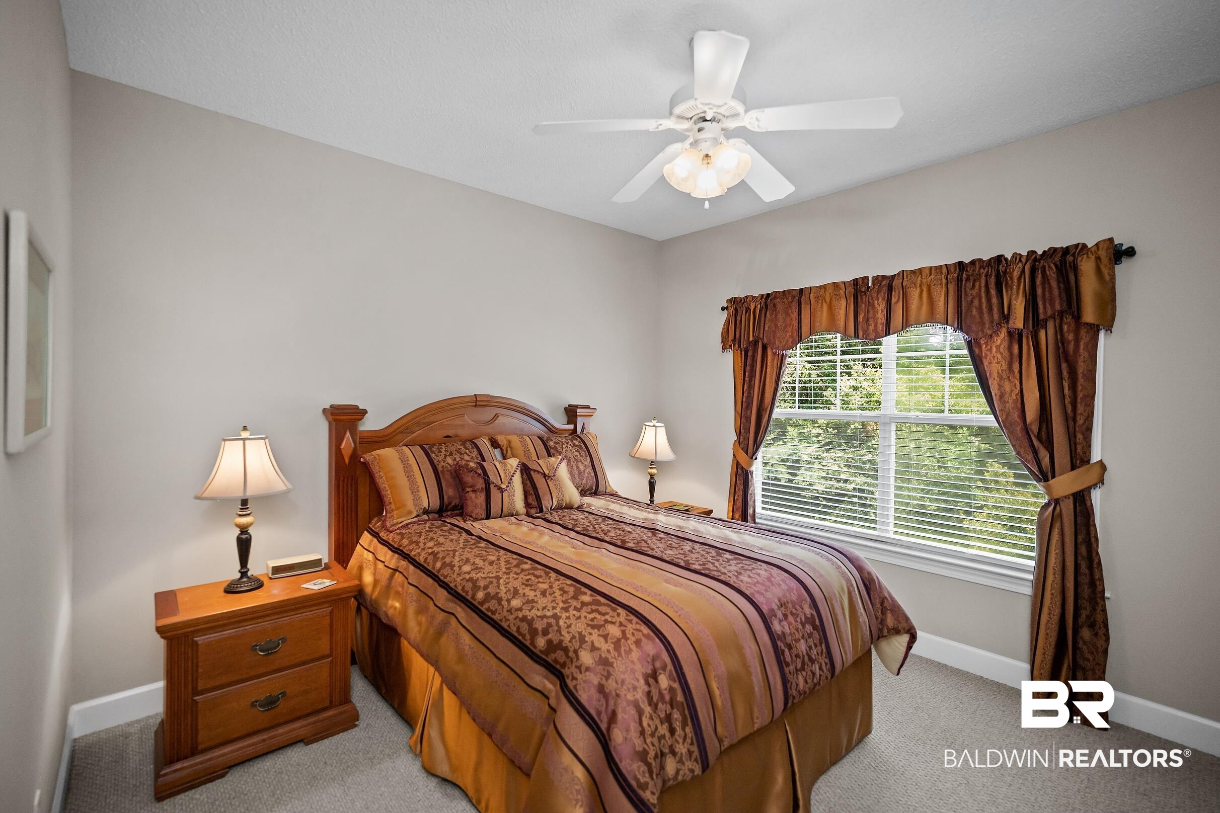 430 West Fort Morgan Road, Unit 704 Gulf Shores, AL 36542 - Photo 15 of 35 Bright bedroom featuring a large window with blinds, a ceiling fan with light fixture, and neutral carpeting