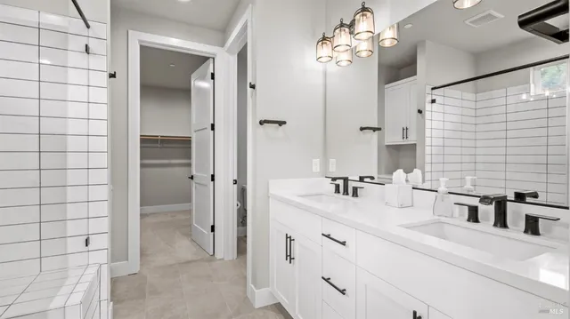 a bathroom with a double vanity sink mirror and shower