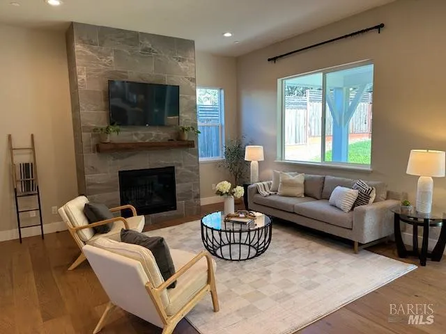 a living room with furniture a fireplace and a flat screen tv