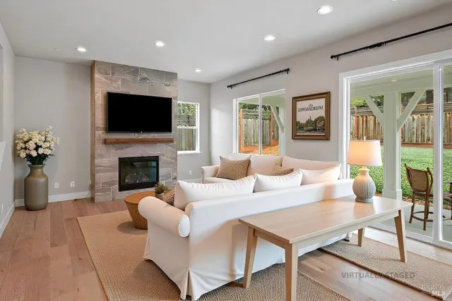 a living room with furniture a fireplace and a flat screen tv
