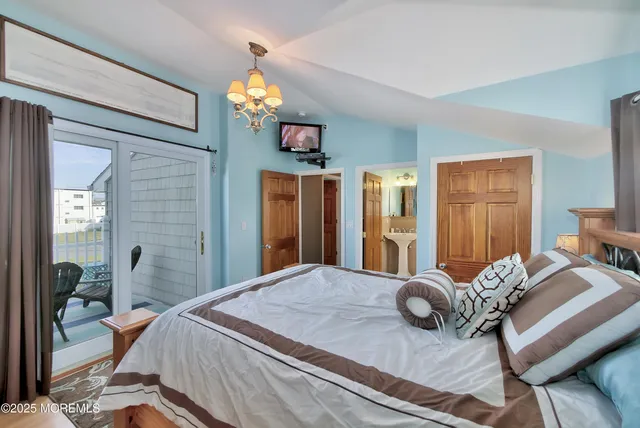 a bedroom with a bed chandelier and a window