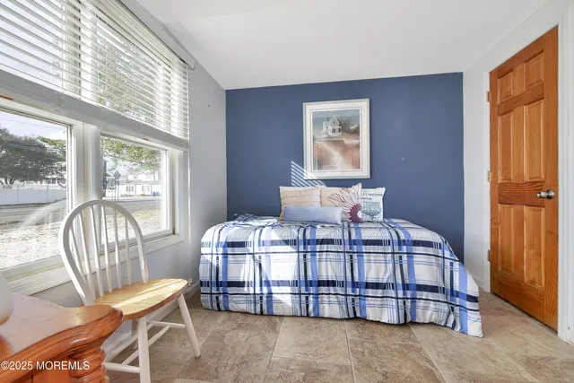 a bedroom with a bed chair and window