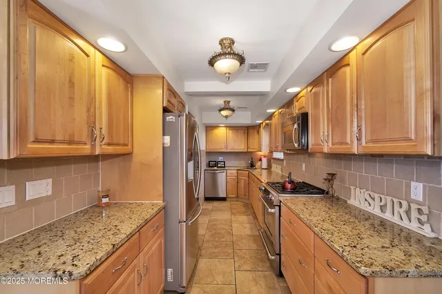 a kitchen with stainless steel appliances granite countertop a sink stove and refrigerator