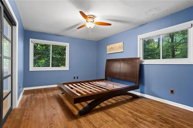 a bedroom with wooden floor and window