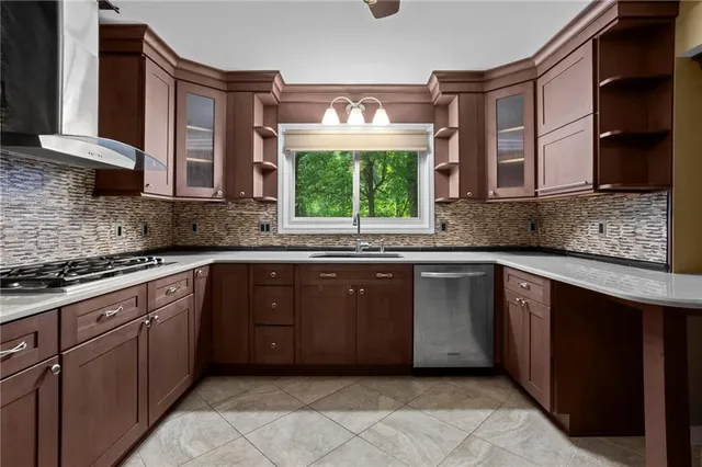 a kitchen with stainless steel appliances granite countertop a sink stove and cabinets