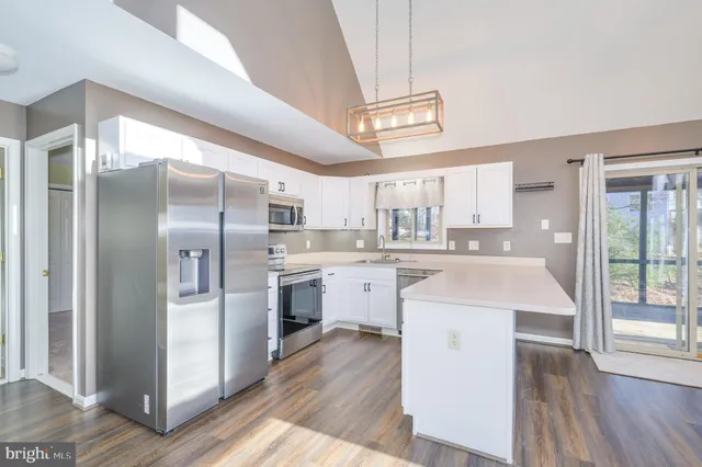 a large kitchen with wooden floor and a sink