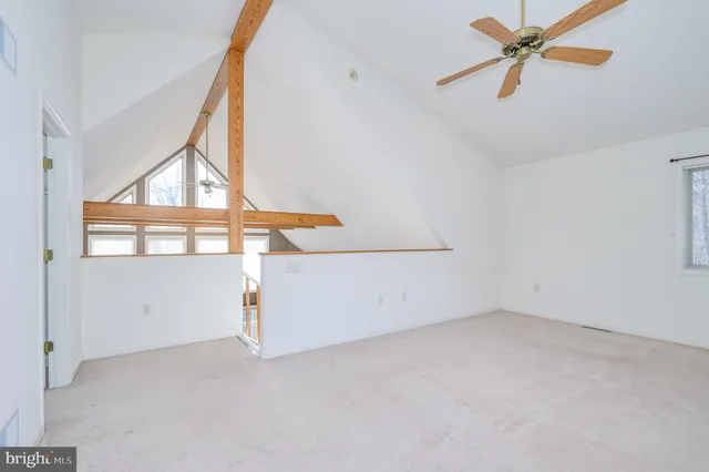 a view of an empty room with a ceiling fan