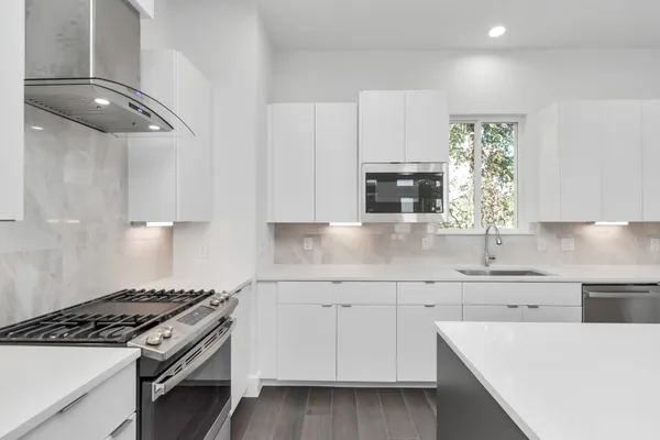 a kitchen with a sink stove and microwave