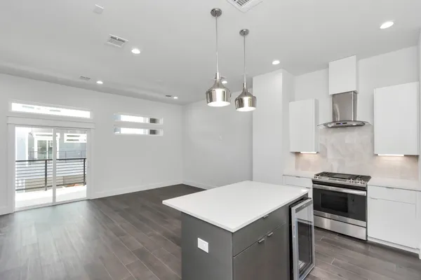 a kitchen that has a sink a microwave a stove and wooden floor