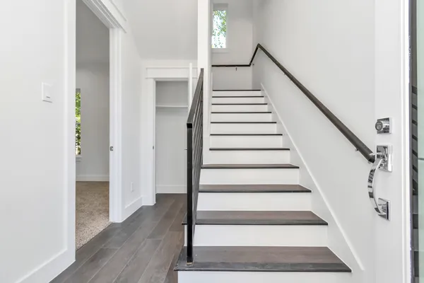 a view of staircase with wooden floor and white walls
