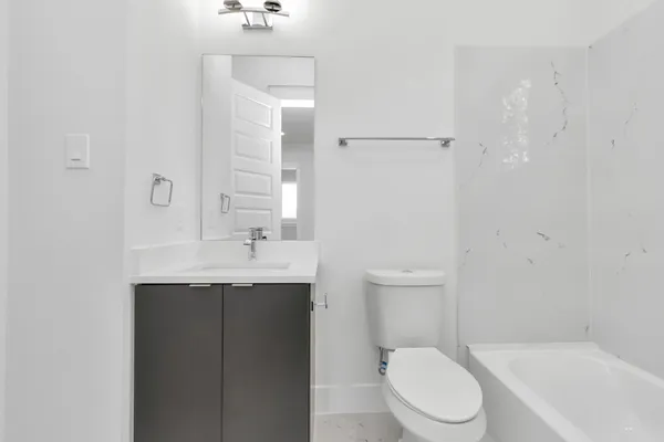 a bathroom with a toilet a sink a mirror and a bathtub