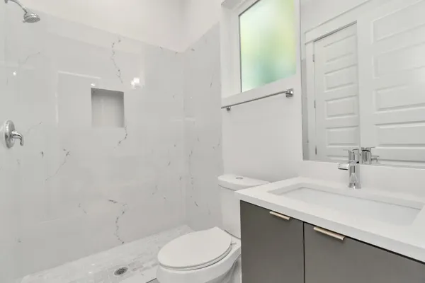 a bathroom with a sink a toilet and shower