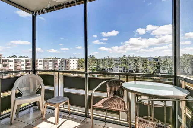 a living room with furniture a flat screen tv and a chandelier