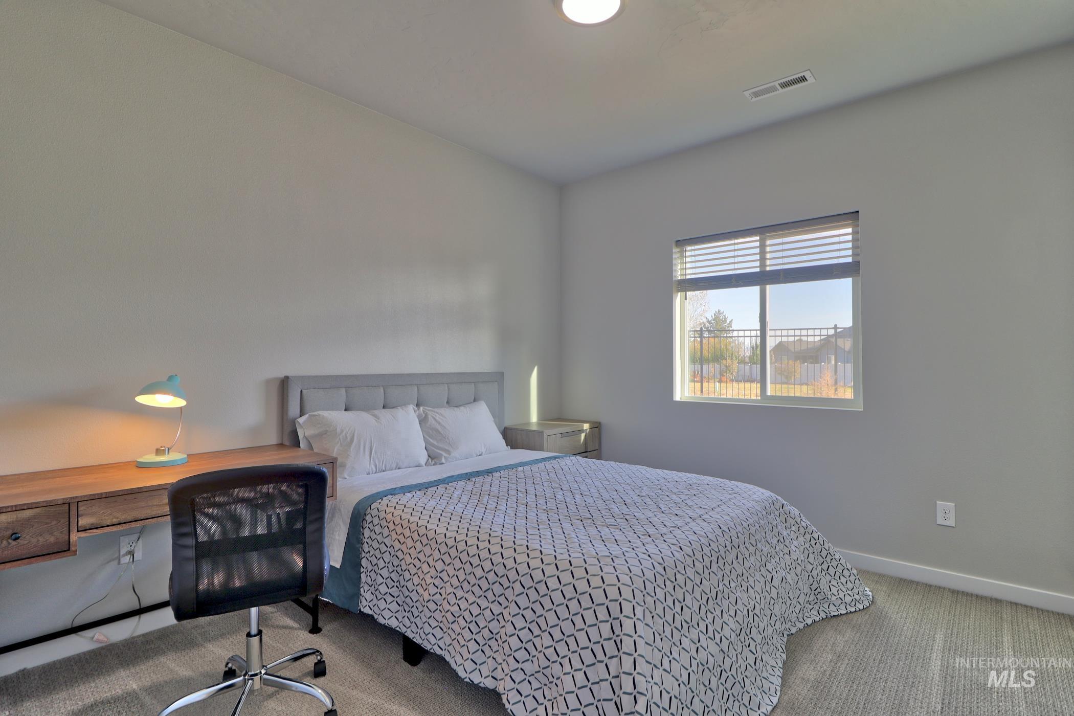 3508 South Edge Rim Way Meridian, ID 83642 - Photo 17 of 28 Bedroom featuring light gray walls, textured carpeting, a window with blinds, and a built-in light fixture