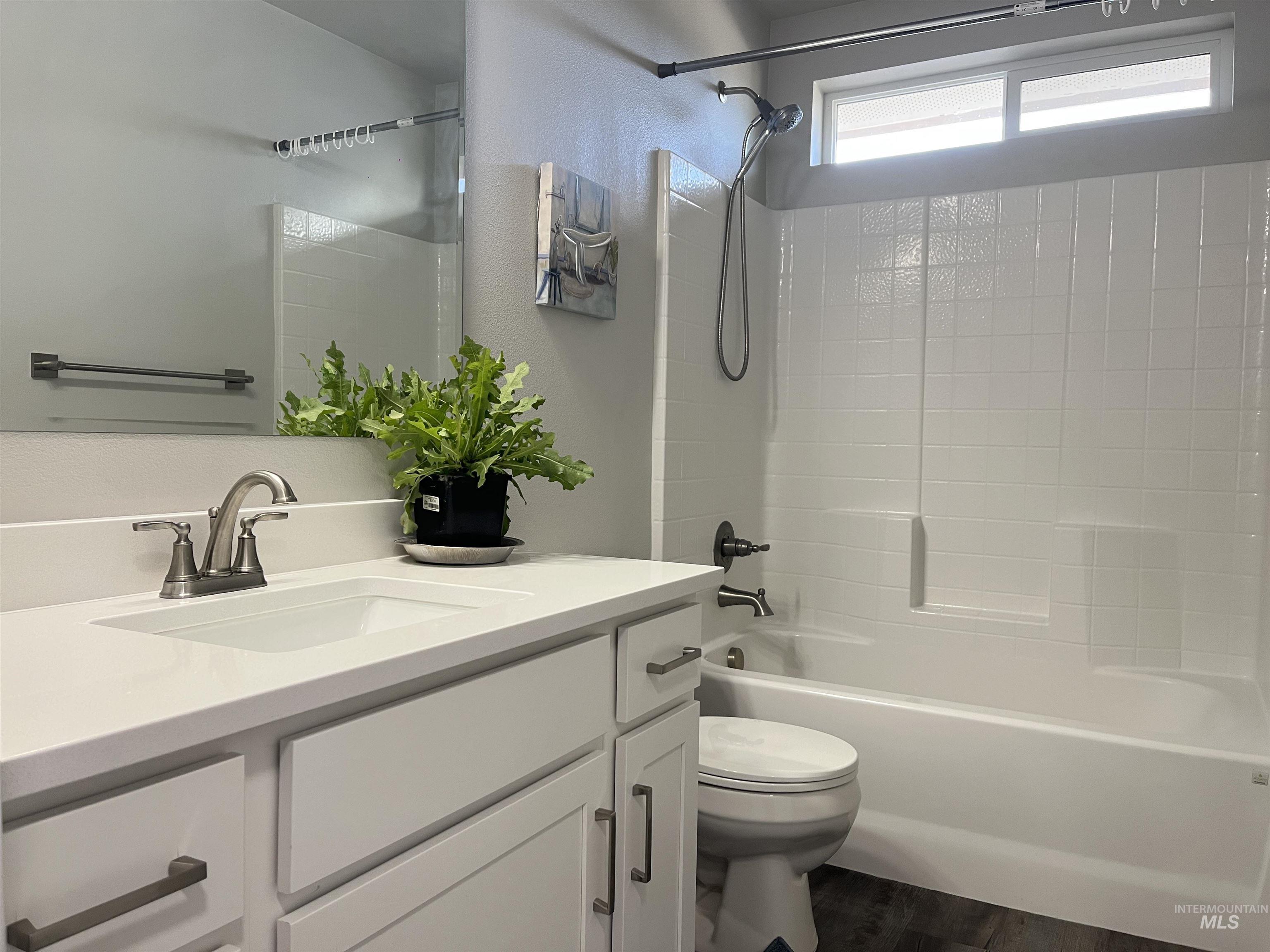 3508 South Edge Rim Way Meridian, ID 83642 - Photo 18 of 28 Bathroom featuring a white vanity with an integrated sink, brushed nickel faucet, and shaker-style cabinetry