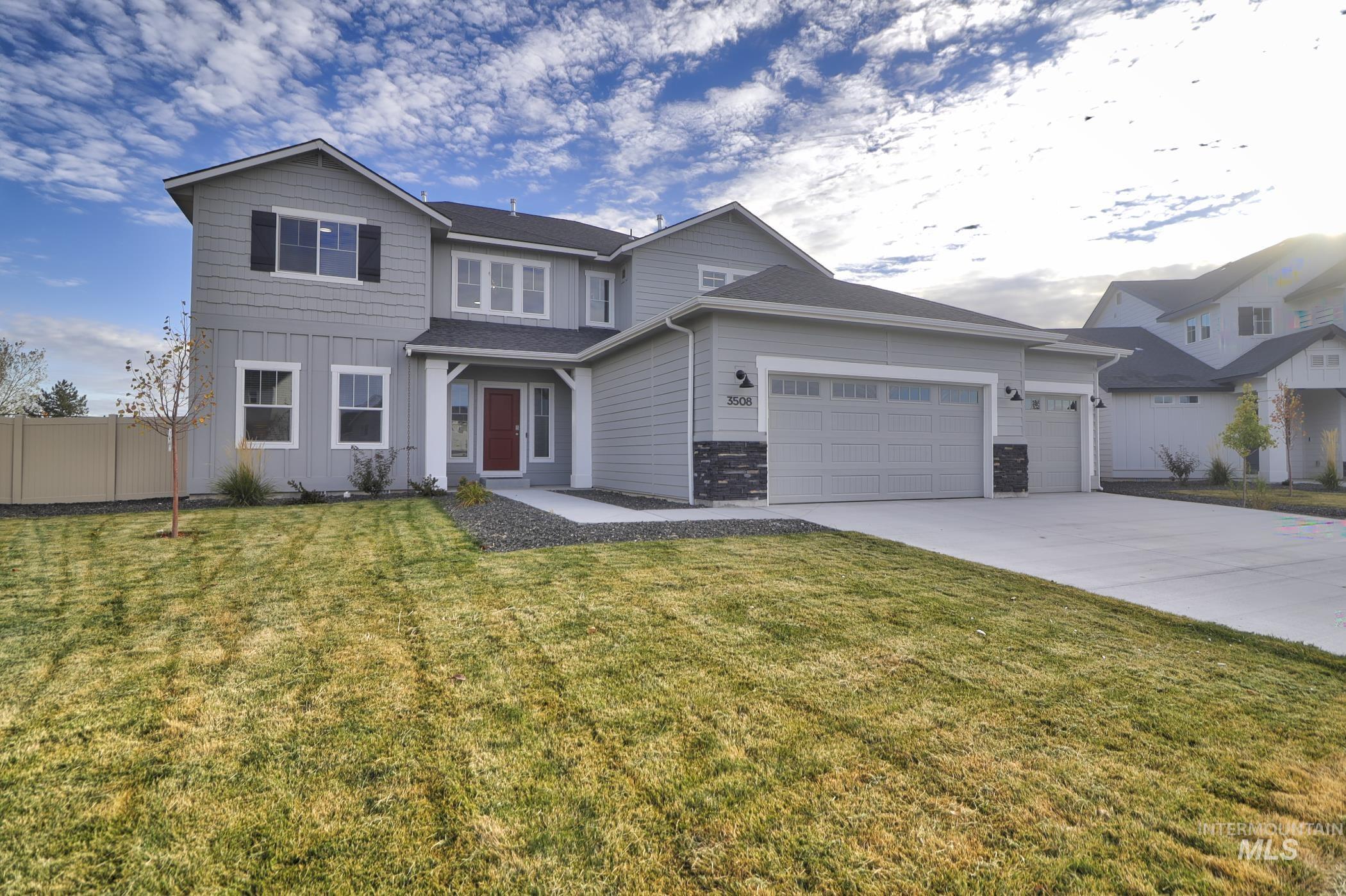 3508 South Edge Rim Way Meridian, ID 83642 - Photo 2 of 28 Contemporary two-story residence featuring light gray siding with contrasting dark shutters, a prominent red front door, and a three-car garage