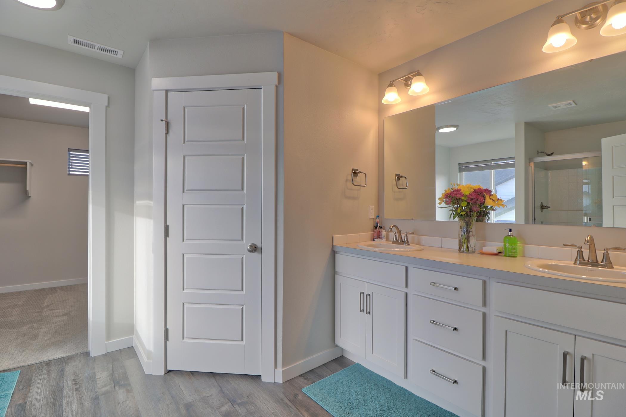 3508 South Edge Rim Way Meridian, ID 83642 - Photo 22 of 28 Bathroom featuring a dual vanity with white cabinetry, light-toned countertops, and two undermount sinks