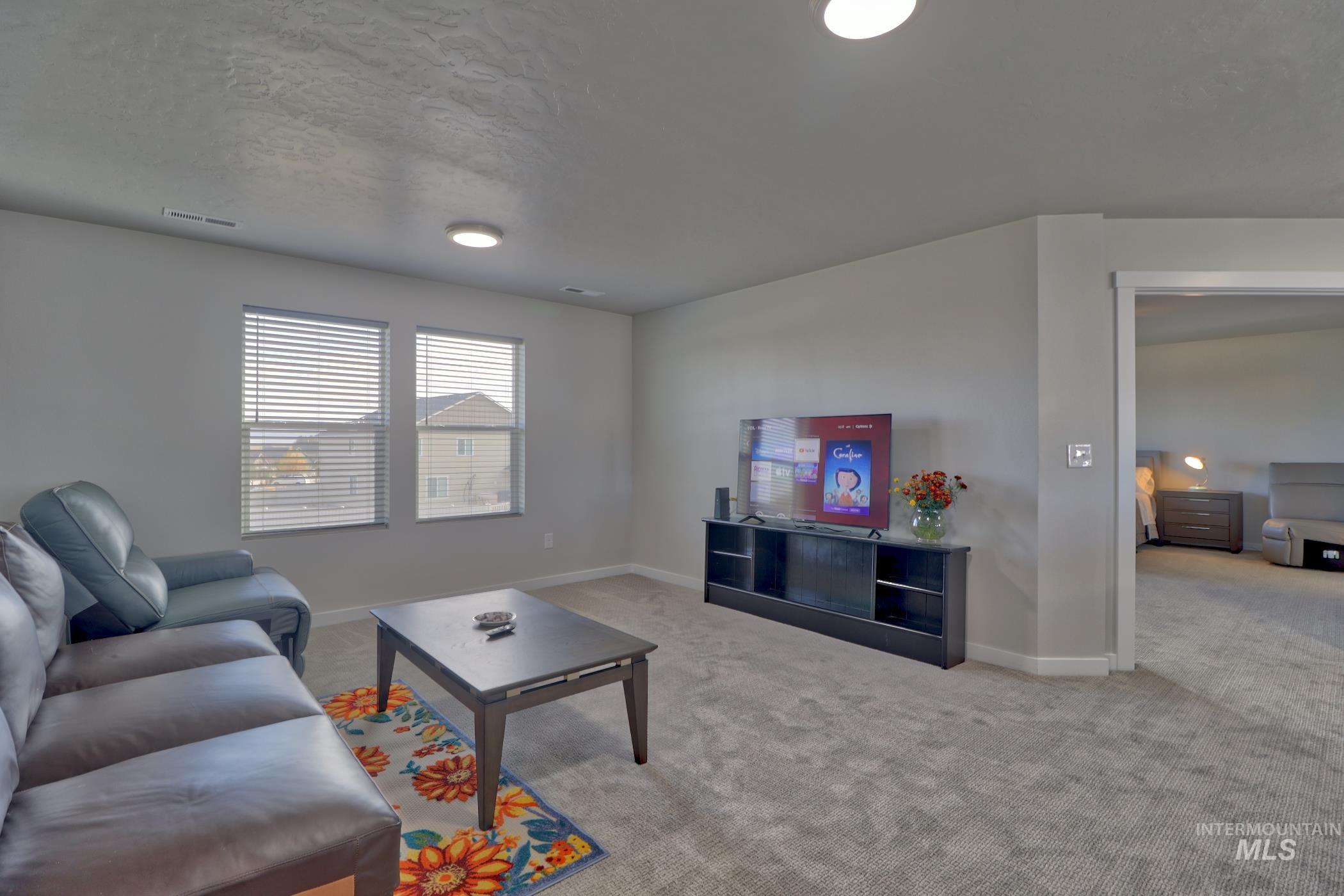3508 South Edge Rim Way Meridian, ID 83642 - Photo 25 of 28 Spacious living area featuring neutral carpeting and light gray wall tones