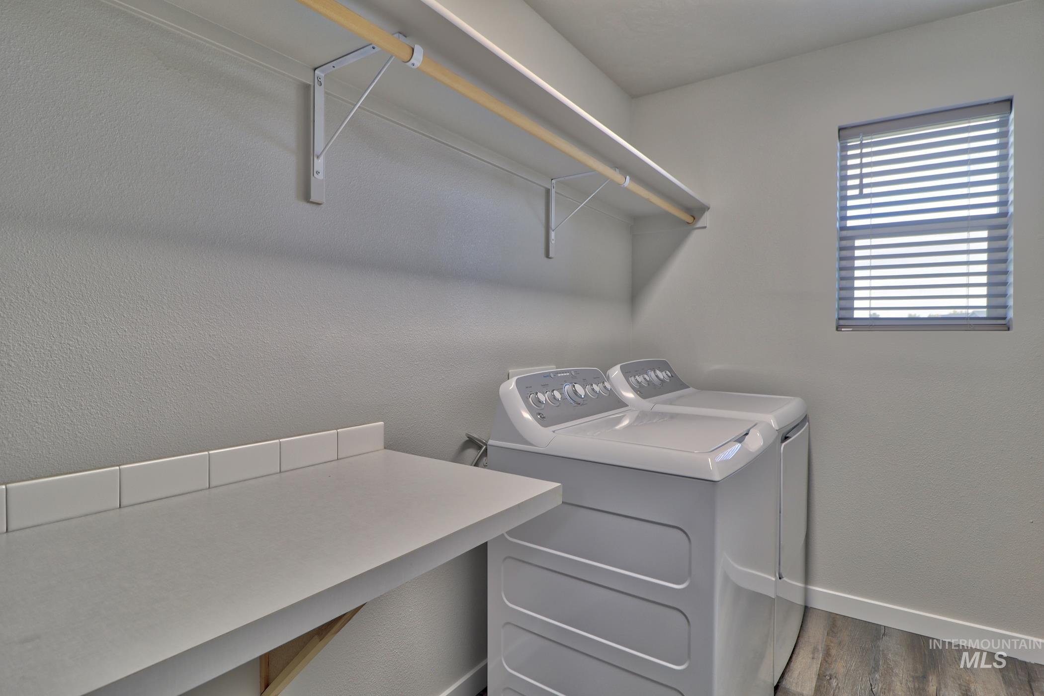 3508 South Edge Rim Way Meridian, ID 83642 - Photo 26 of 28 Dedicated utility room featuring a window with blinds, a built-in countertop with a tile backsplash, and a wall-mounted shelving unit with a hanging rod