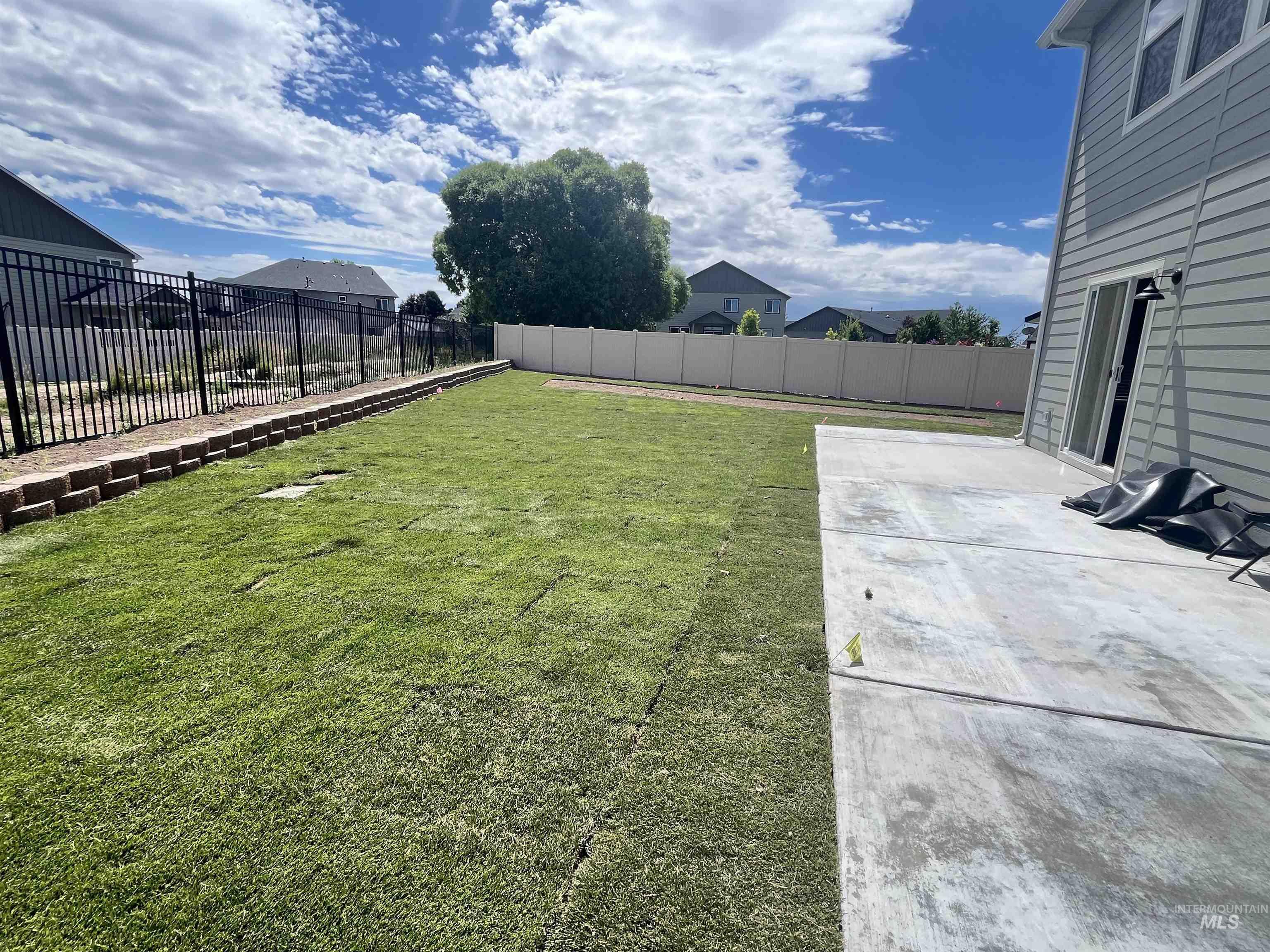3508 South Edge Rim Way Meridian, ID 83642 - Photo 27 of 28 Expansive backyard featuring a newly laid lawn, a concrete patio, and a light-colored vinyl privacy fence