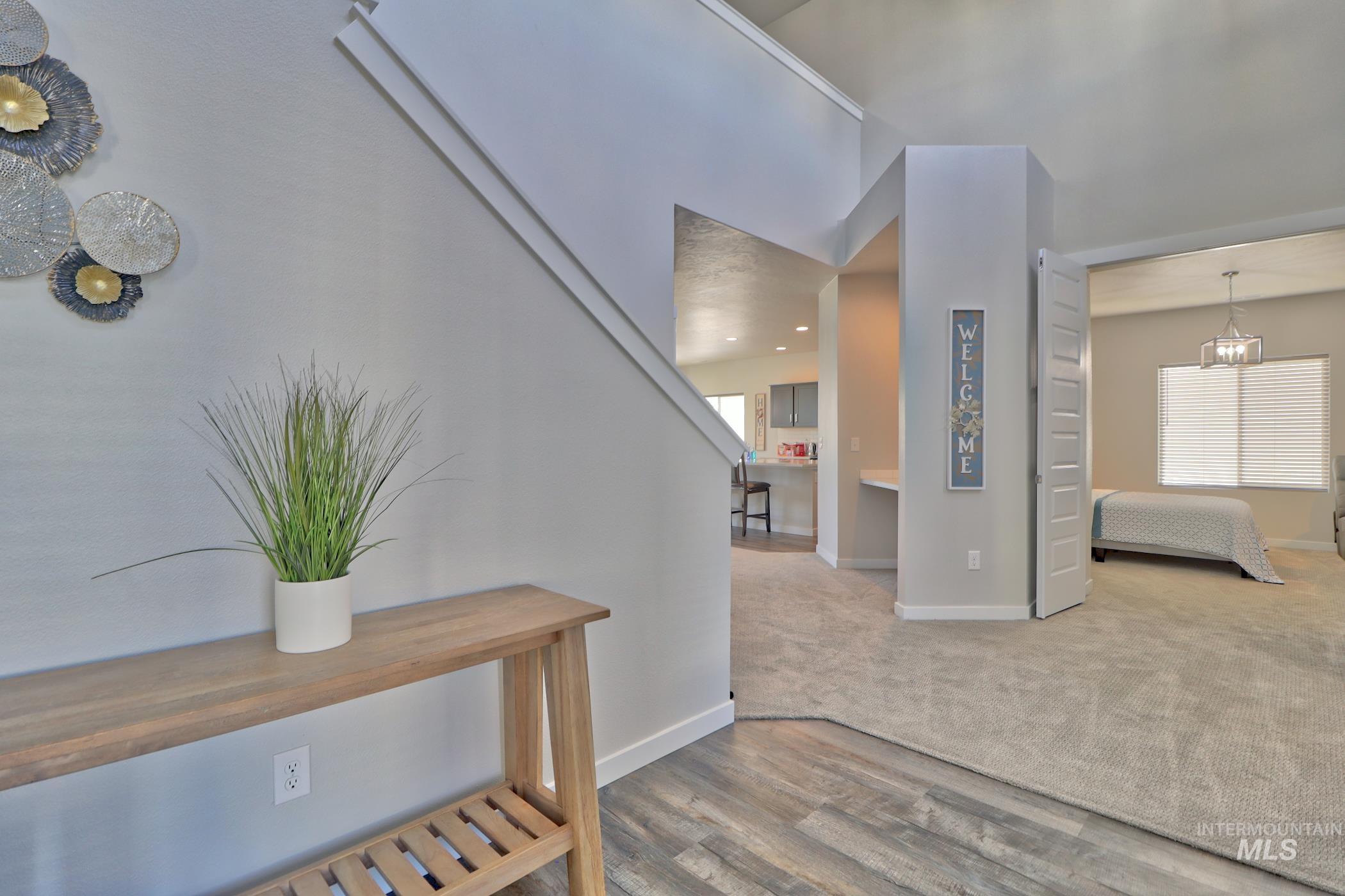 3508 South Edge Rim Way Meridian, ID 83642 - Photo 3 of 28 Entryway with wood-finish flooring transitioning to carpet, staircase with painted risers, and a built-in desk nook