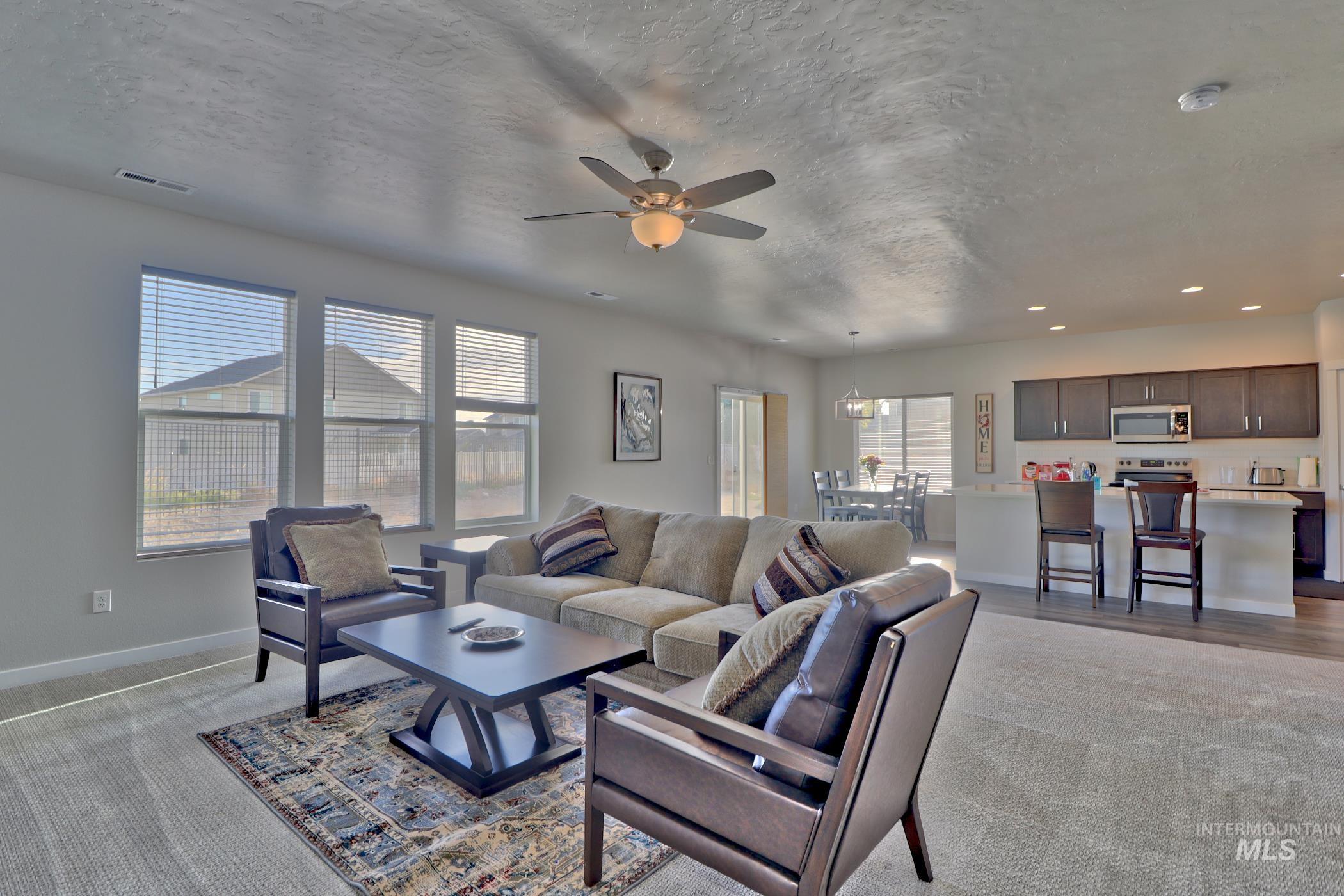 3508 South Edge Rim Way Meridian, ID 83642 - Photo 6 of 28 Expansive open-concept living area featuring a ceiling fan with integrated lighting