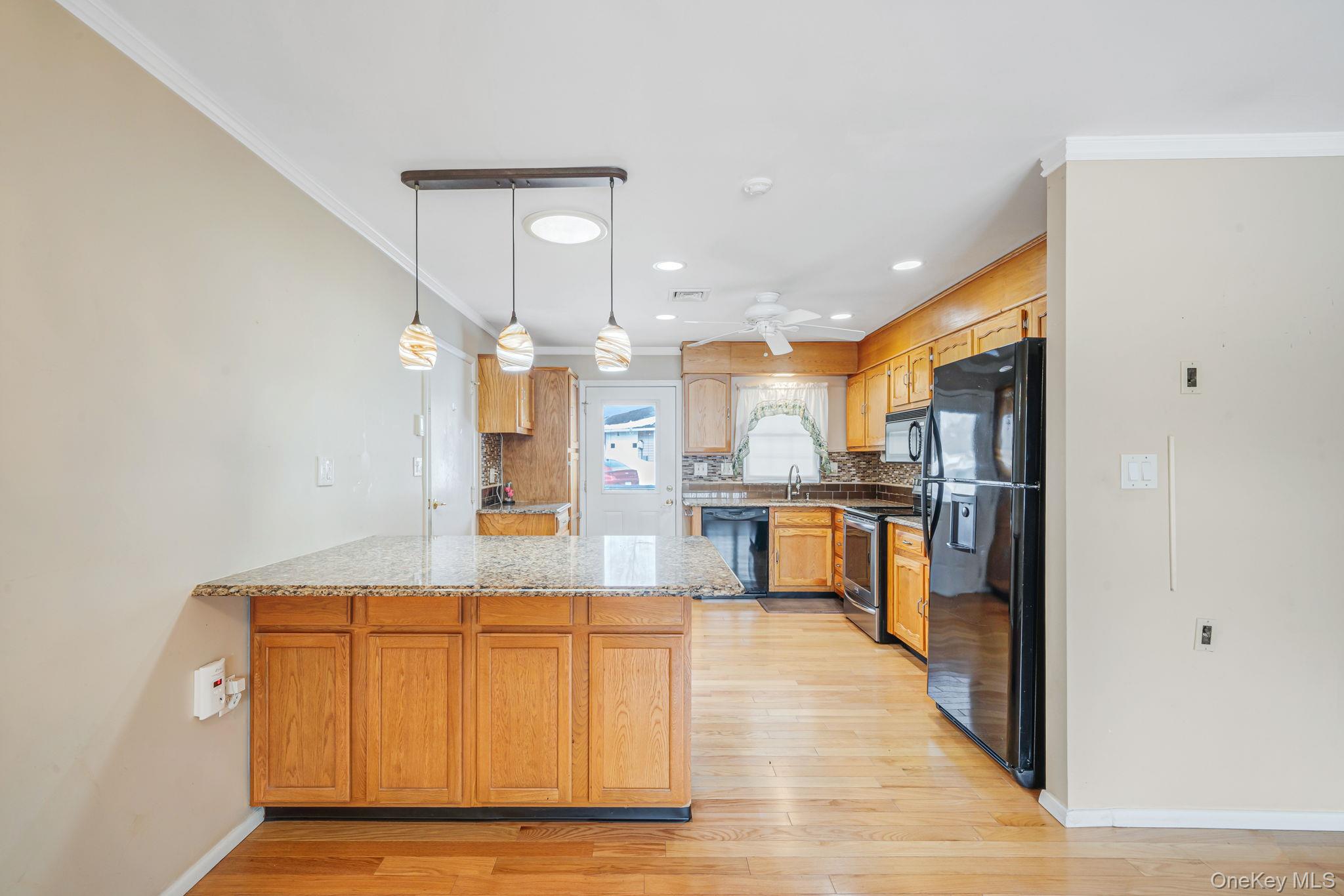 61 Enfield Court, Unit B Ridge, NY 11961 - Photo 11 of 32 a living room with stainless steel appliances kitchen island granite countertop furniture and a kitchen view