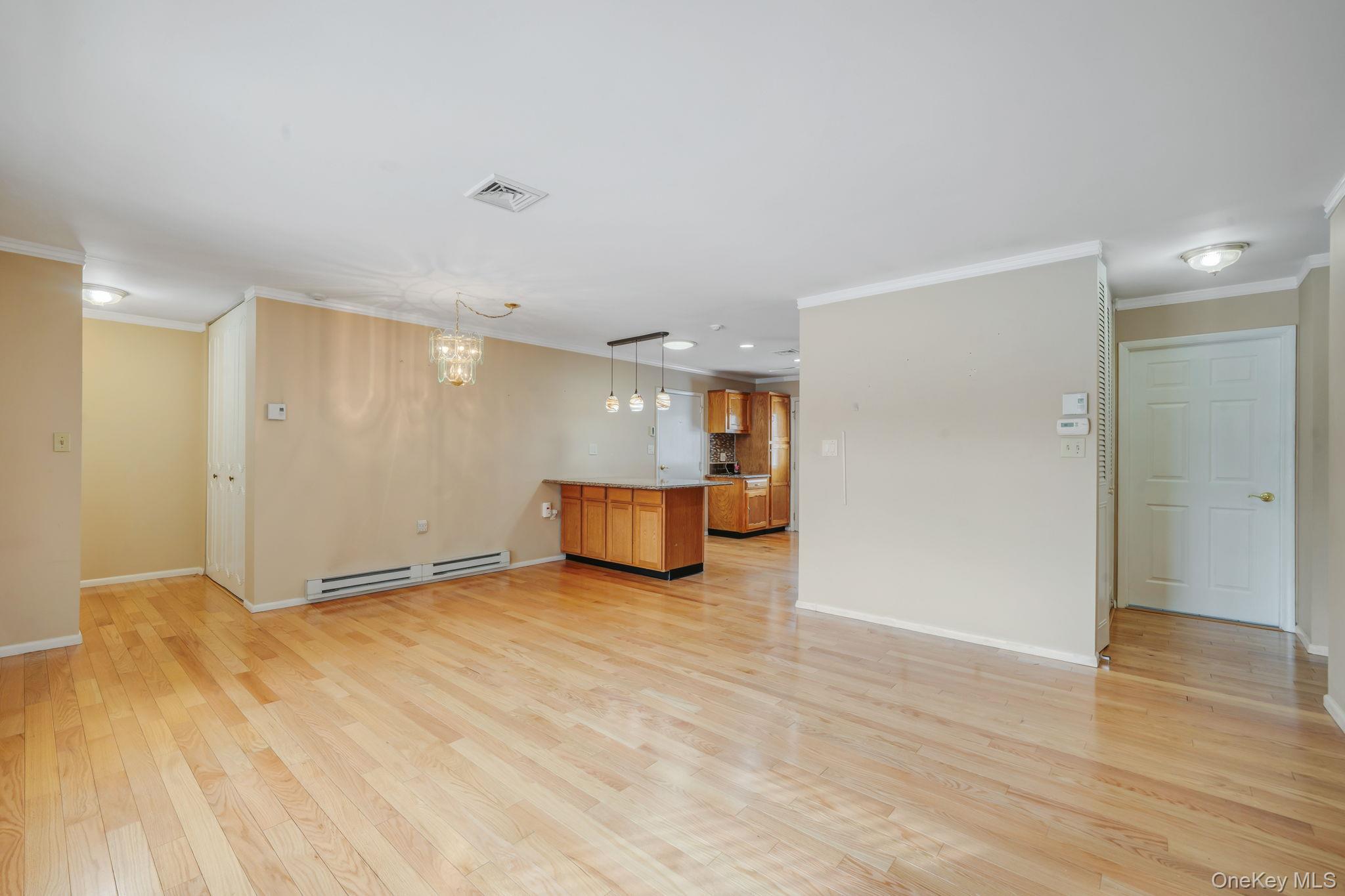 61 Enfield Court, Unit B Ridge, NY 11961 - Photo 15 of 32 a view of an empty room with wooden floor
